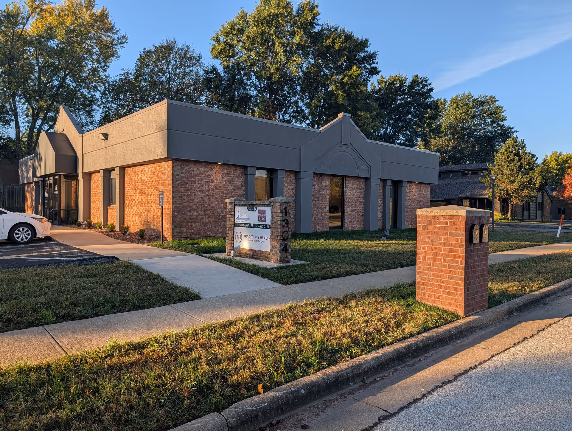 Exterior of Sacred Rose Healthcare building with brick walls and a front sidewalk.