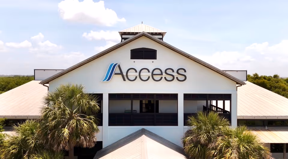 Front exterior of a building with an Access sign and palm trees by the entrance.