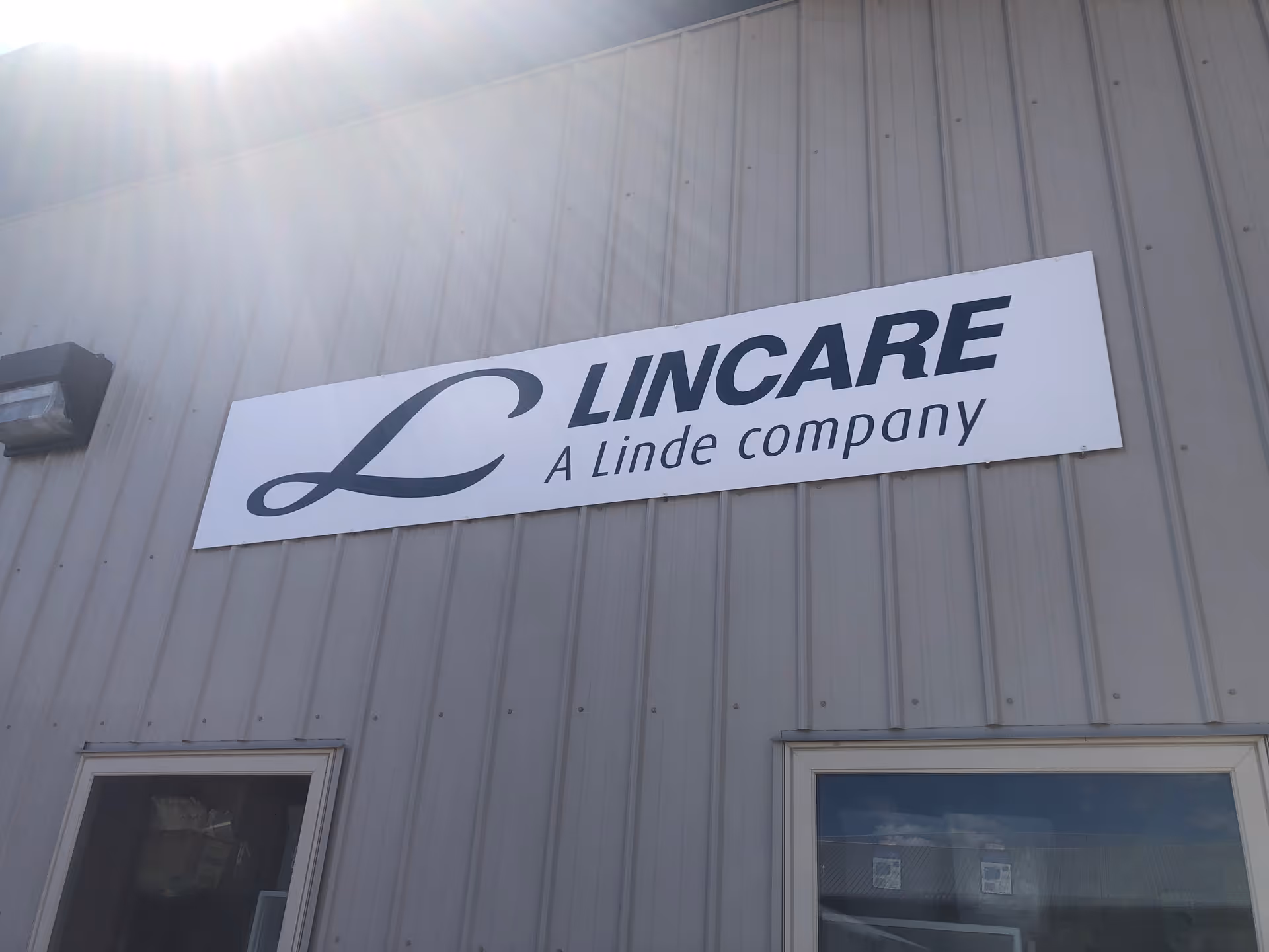 Exterior view of a LINCARE sign mounted on a metal-clad building.