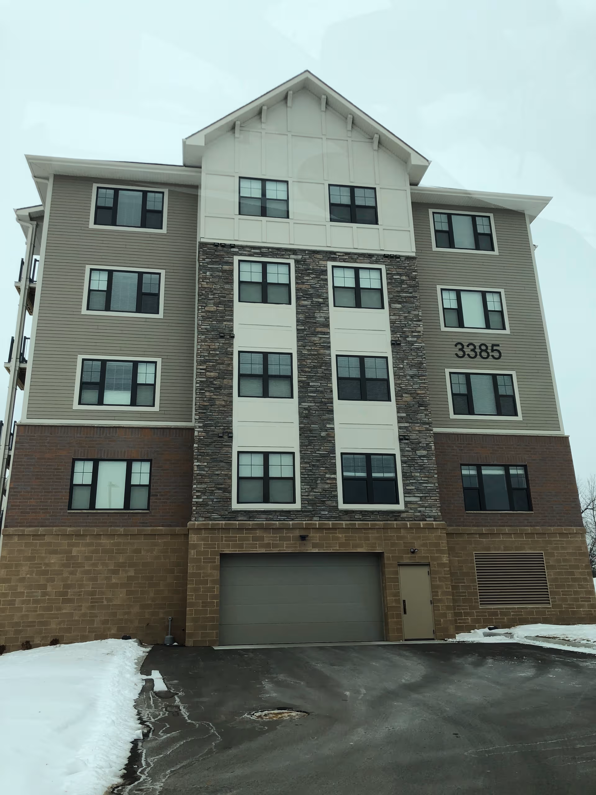 Multi-story senior living building exterior with stone panels and the number 3385 on the facade.