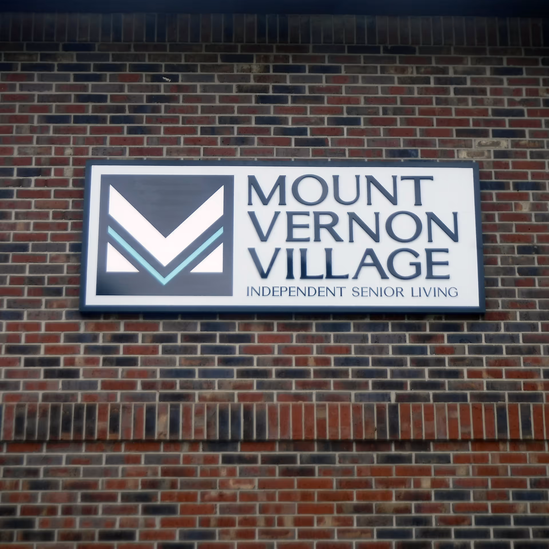 Mount Vernon Village sign mounted on a brick exterior wall of the building