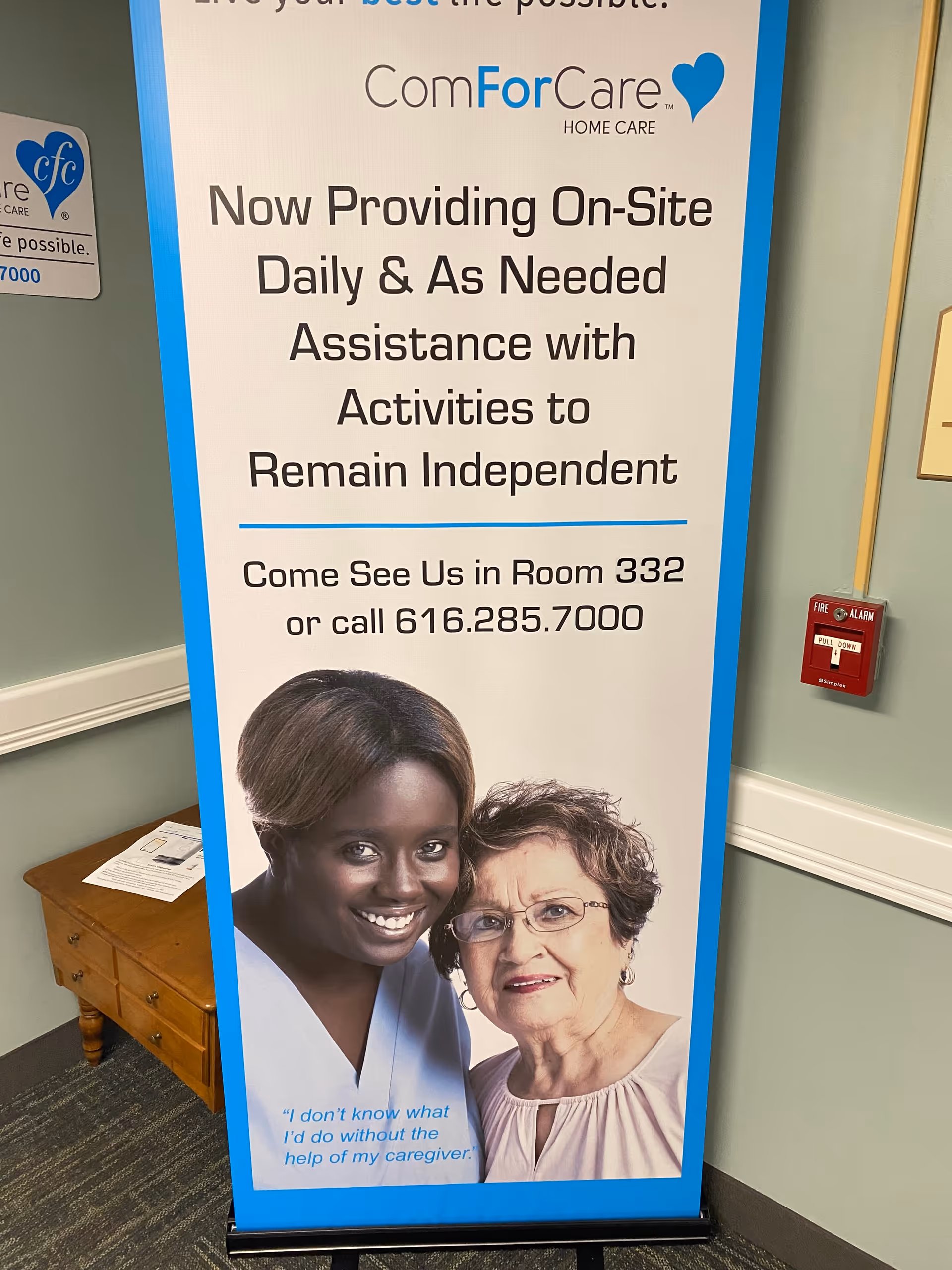 Tall banner sign for ComForCare Home Care Grand Rapids in a hallway.
