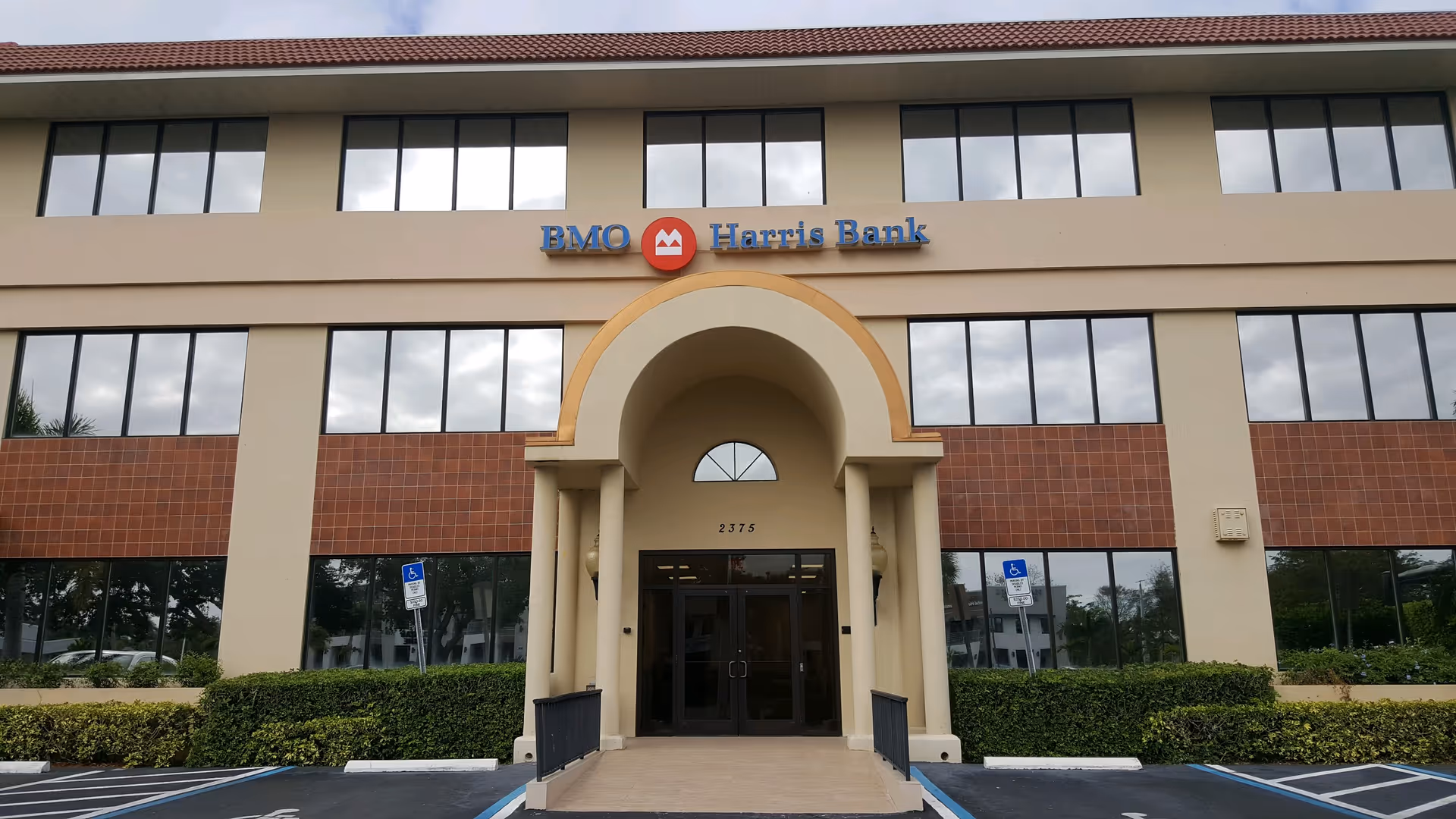 Exterior view of a beige building with an arched entrance and a BMO Harris Bank sign.