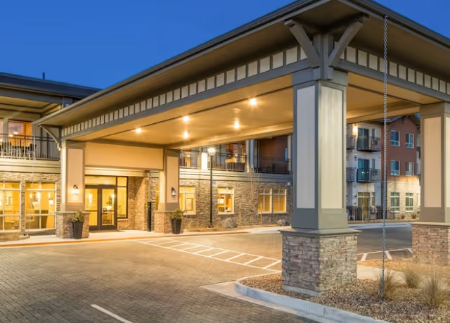 Exterior view of Affinity at Fort Collins entrance with covered drop-off and lamps.