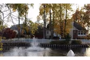 Front view of St. Bernards Village building with a pond and fountain.