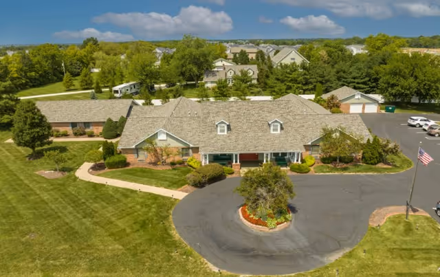 Aerial view of Caregivers Inn front exterior with circular driveway and landscaped grounds.