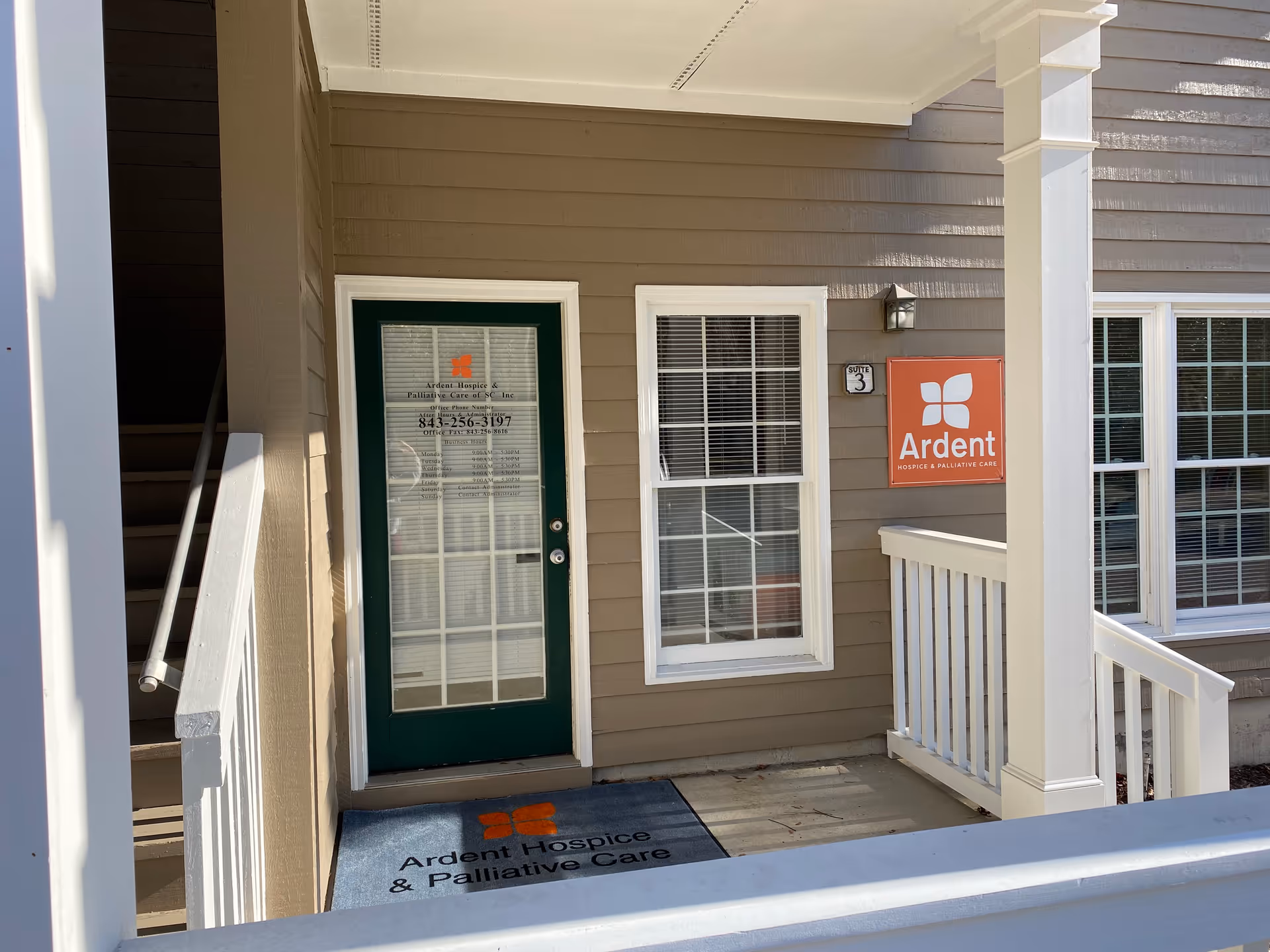 Exterior entrance of a senior care building with green door and Ardent sign.