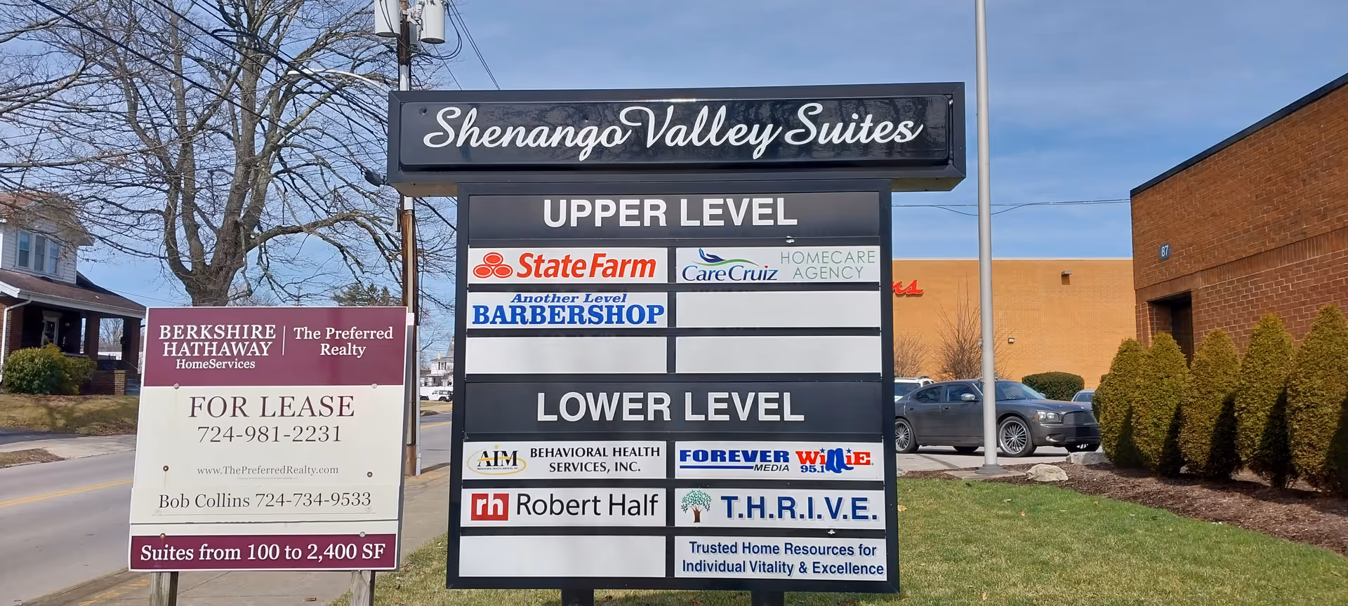 Outdoor signboard lists CareCruiz Homecare Agency LLC among tenants near a building.