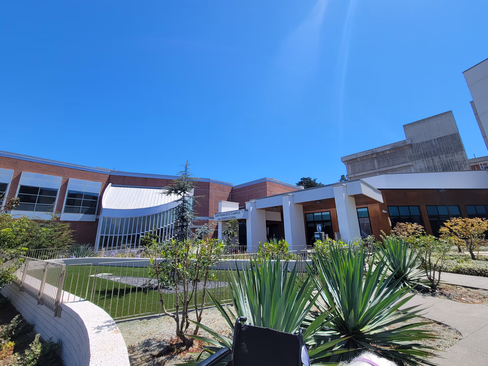Exterior view of San Francisco Campus for Jewish Living entrance with landscaping and blue sky.