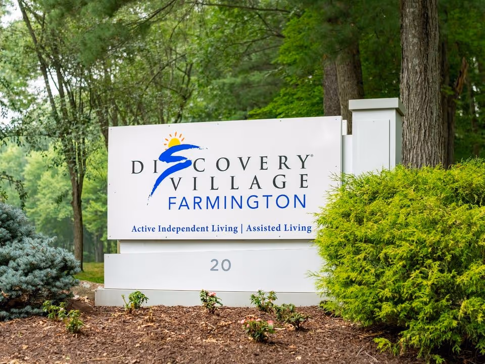 Outdoor Discovery Village Farmington sign with landscaping and trees