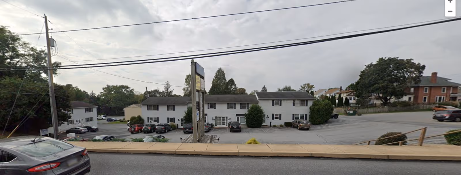 Exterior view of Upper-Class Home Care, a white two-story facility with a parking lot.