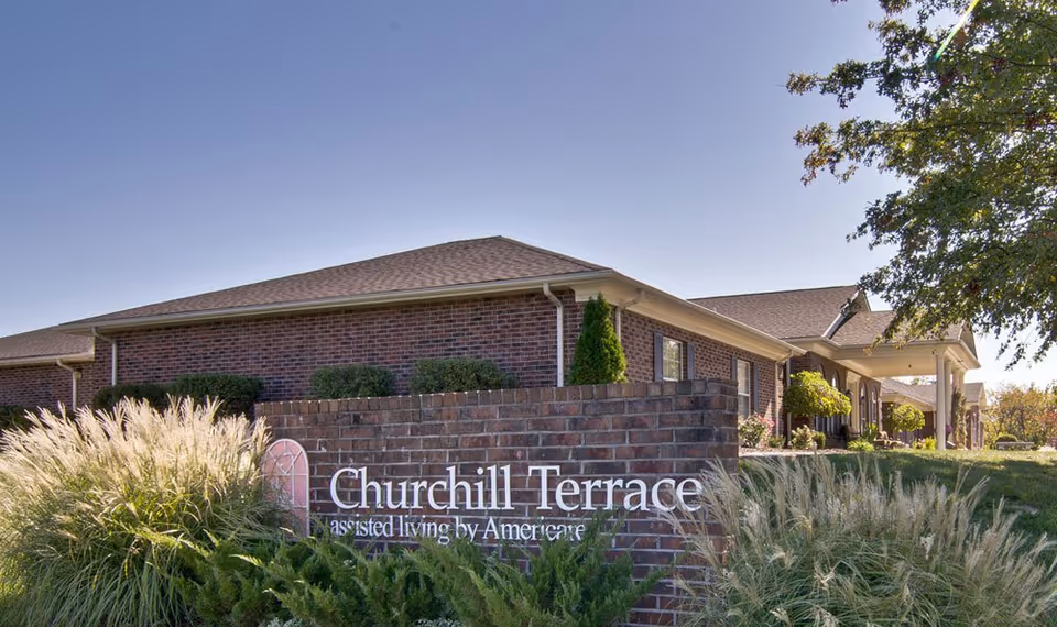 Brick Churchill Terrace senior living facility features a landscaped front and entry sign.
