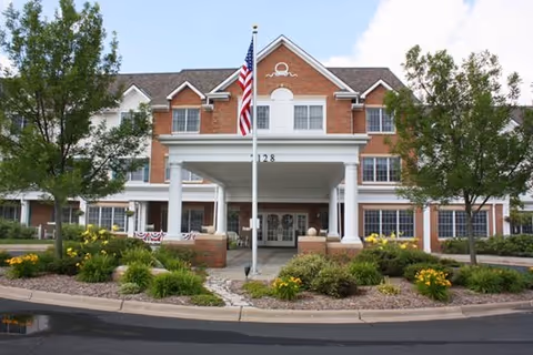 Exterior view of Sunrise of Edina senior living facility entrance with flagpole.