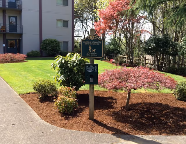 Exterior view of Willamette Lutheran Retirement campus with a leash sign and landscaped garden.