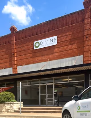 Brick storefront with Divine Home Care Services Hillsboro sign and a white van parked outside