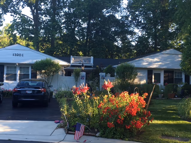 Exterior view of Caring Hearts and Hands Assisted Living with a colorful front garden.