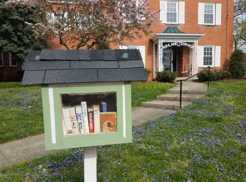 Brick Ashland Terrace senior living facility with a front entrance and a small book box.