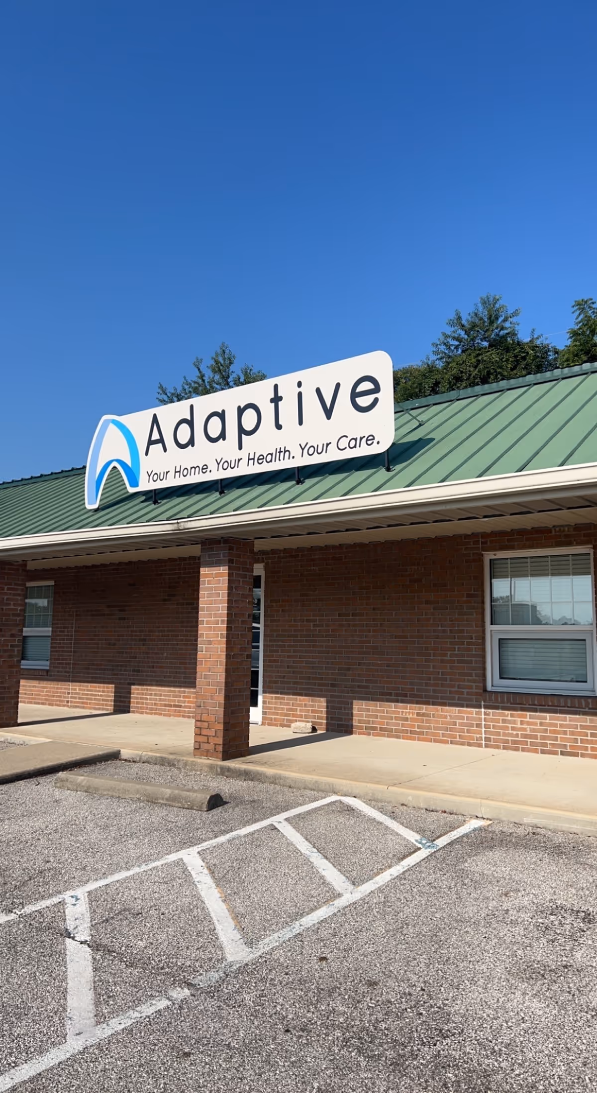 Exterior view of Adaptive Nursing and Healthcare Services facility with brick walls and sign.