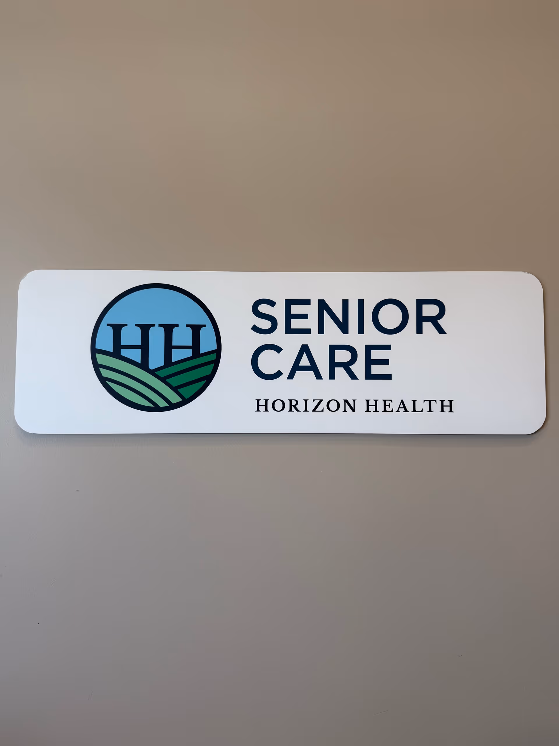 Interior wall sign reading Senior Care Horizon Health with a blue circular logo.