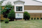 Front view of a Senior Villages building with sign and manicured lawn.
