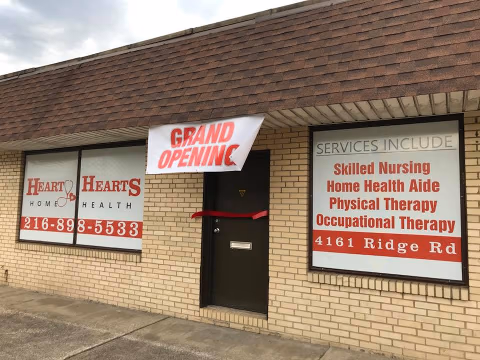 Exterior brick building with Hearty Hearts Home Health banners advertising services and grand opening.