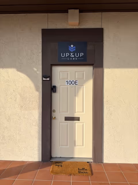 Exterior entrance to Up and Up Care facility with front door and mat