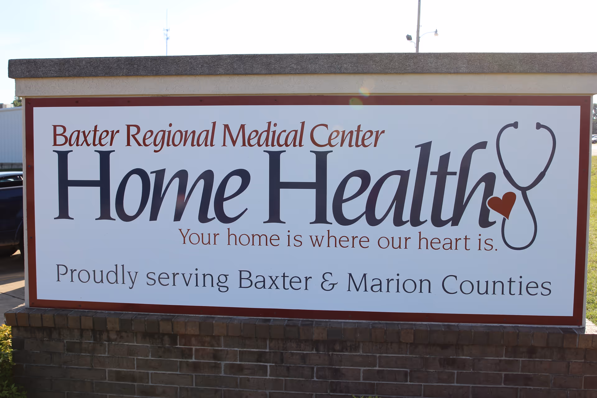 Large outdoor sign reading Baxter Regional Medical Center Home Health on brick pedestal.