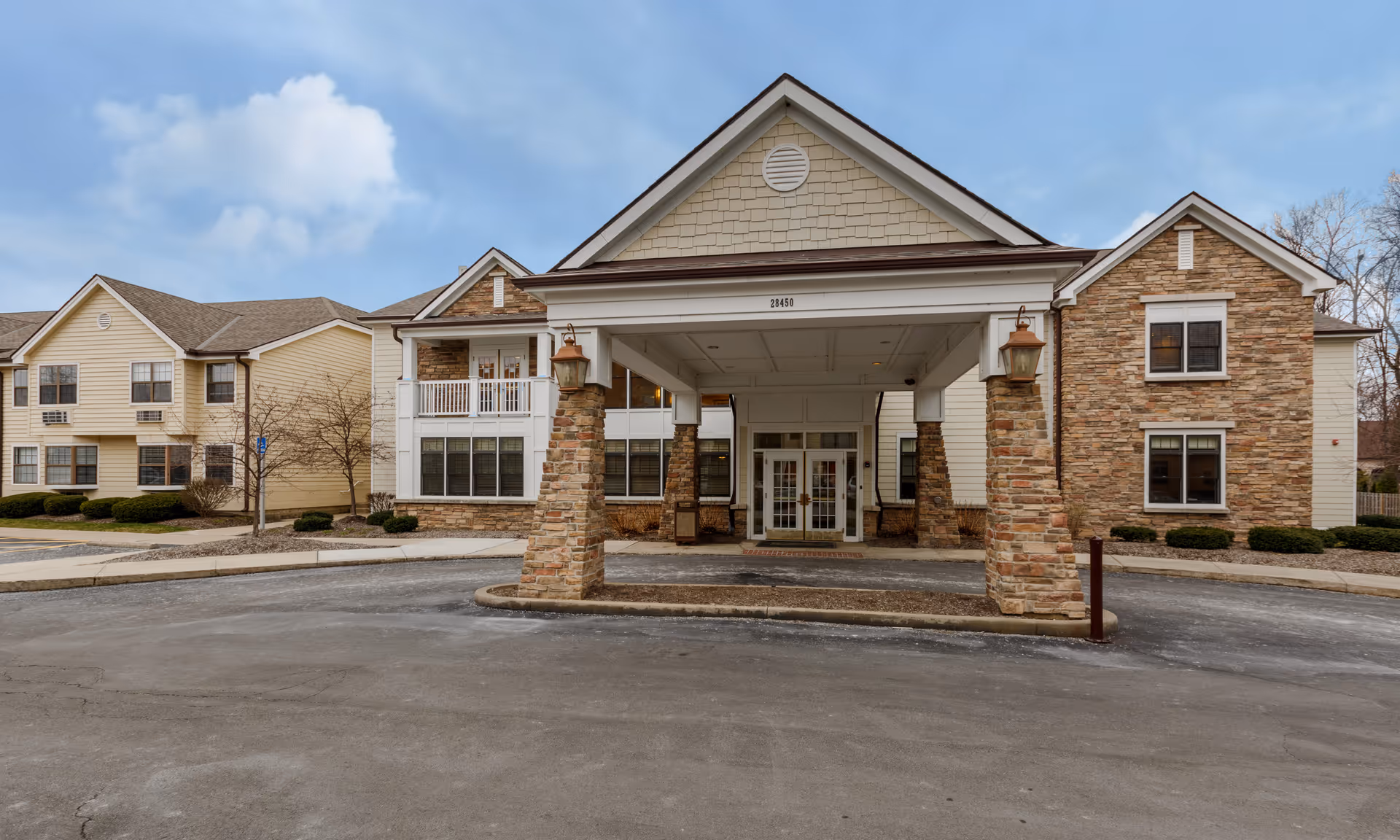 Exterior view of Cedarhurst Senior Living entrance with porte-cochere and stone columns.
