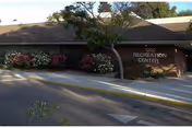 Exterior view of a single-story facility with a Recreation Center sign and landscaping.