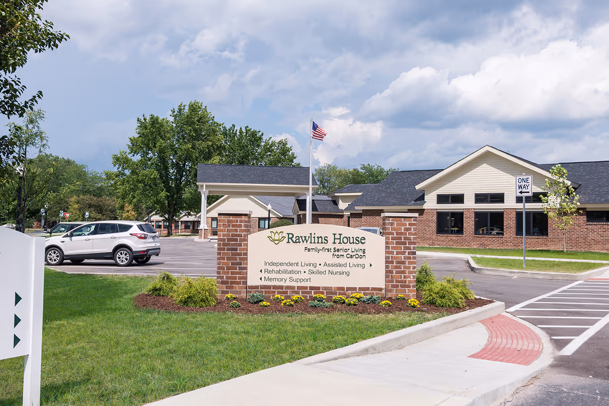 Exterior view of Rawlins House senior living facility with brick building and sign.