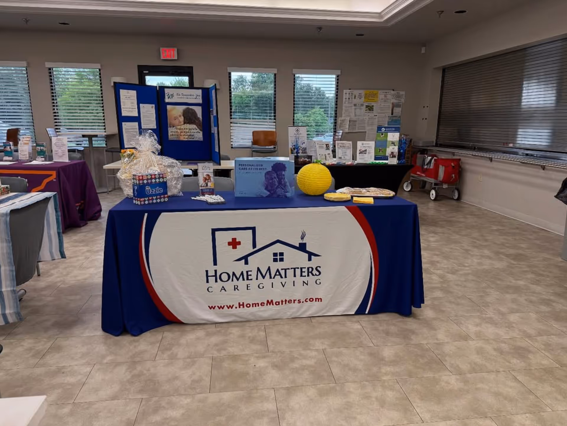 Indoor event table with Home Matters Caregiving branding and informational displays.