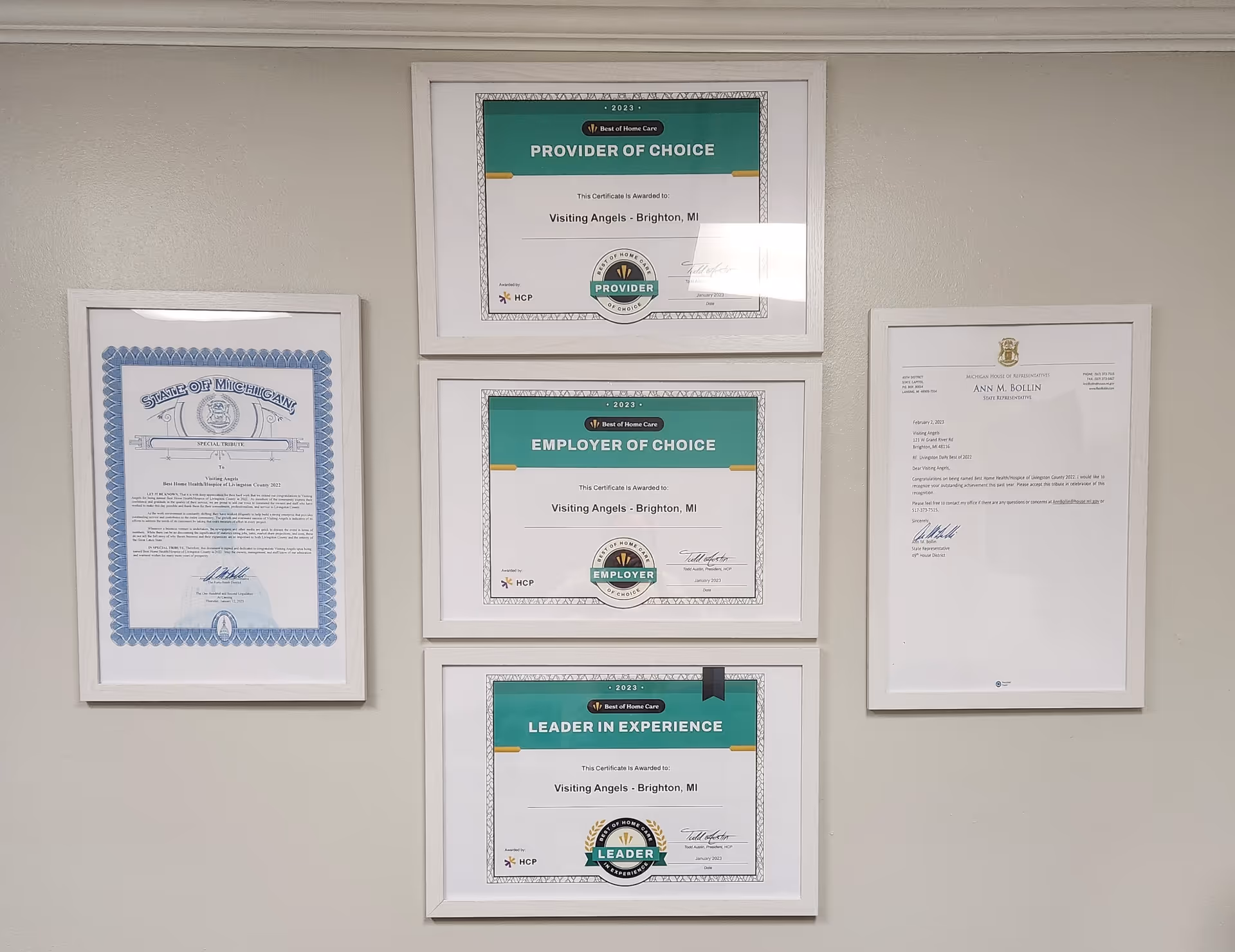 Beige wall displaying framed certificates and awards in a senior care facility.