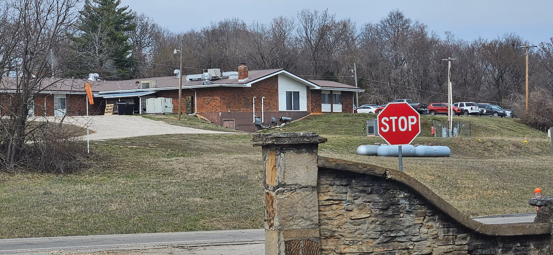 Brick senior living facility exterior with stop sign and curved stone entrance