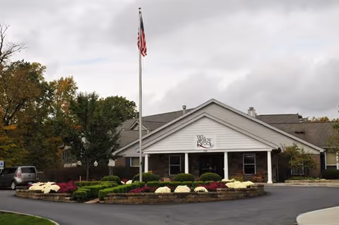 Front view of Willow Brook Christian Village with flagpole and landscaped circular garden.