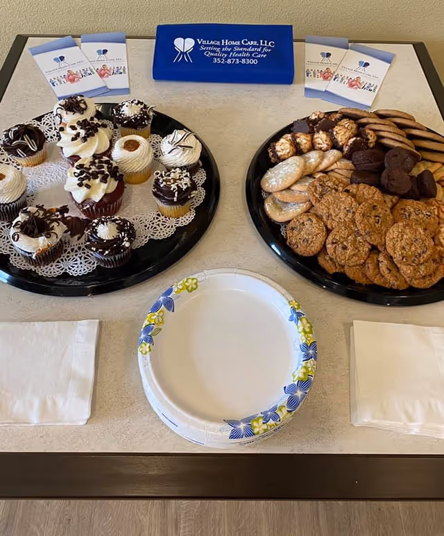 Tray of cupcakes and cookies on a table in a senior living facility common area.