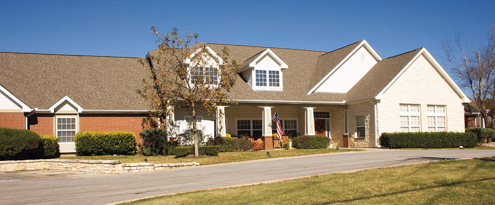 Exterior view of Brookdale Western Hills, brick building with a gabled roof and landscaped frontage.