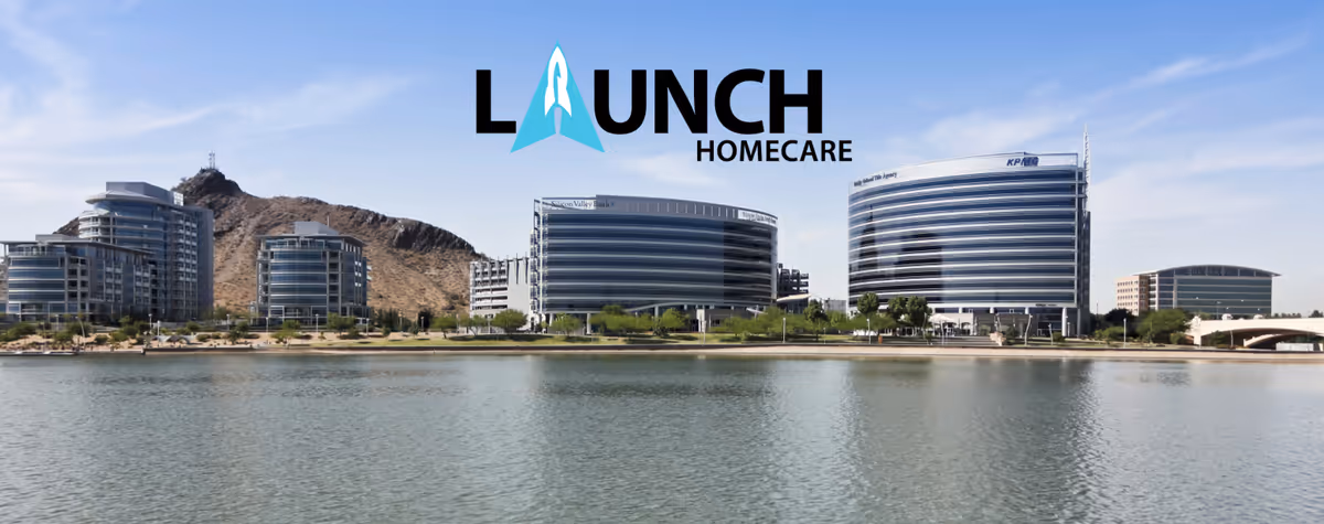 Wide waterfront view of modern senior living buildings with Launch Homecare logo.