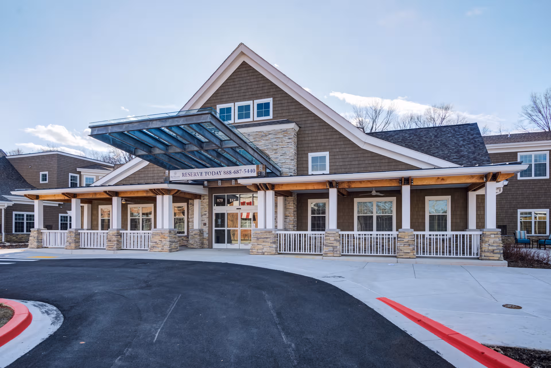 Entrance to Sunrise at Bay Village senior living facility with a covered porch and stone accents.