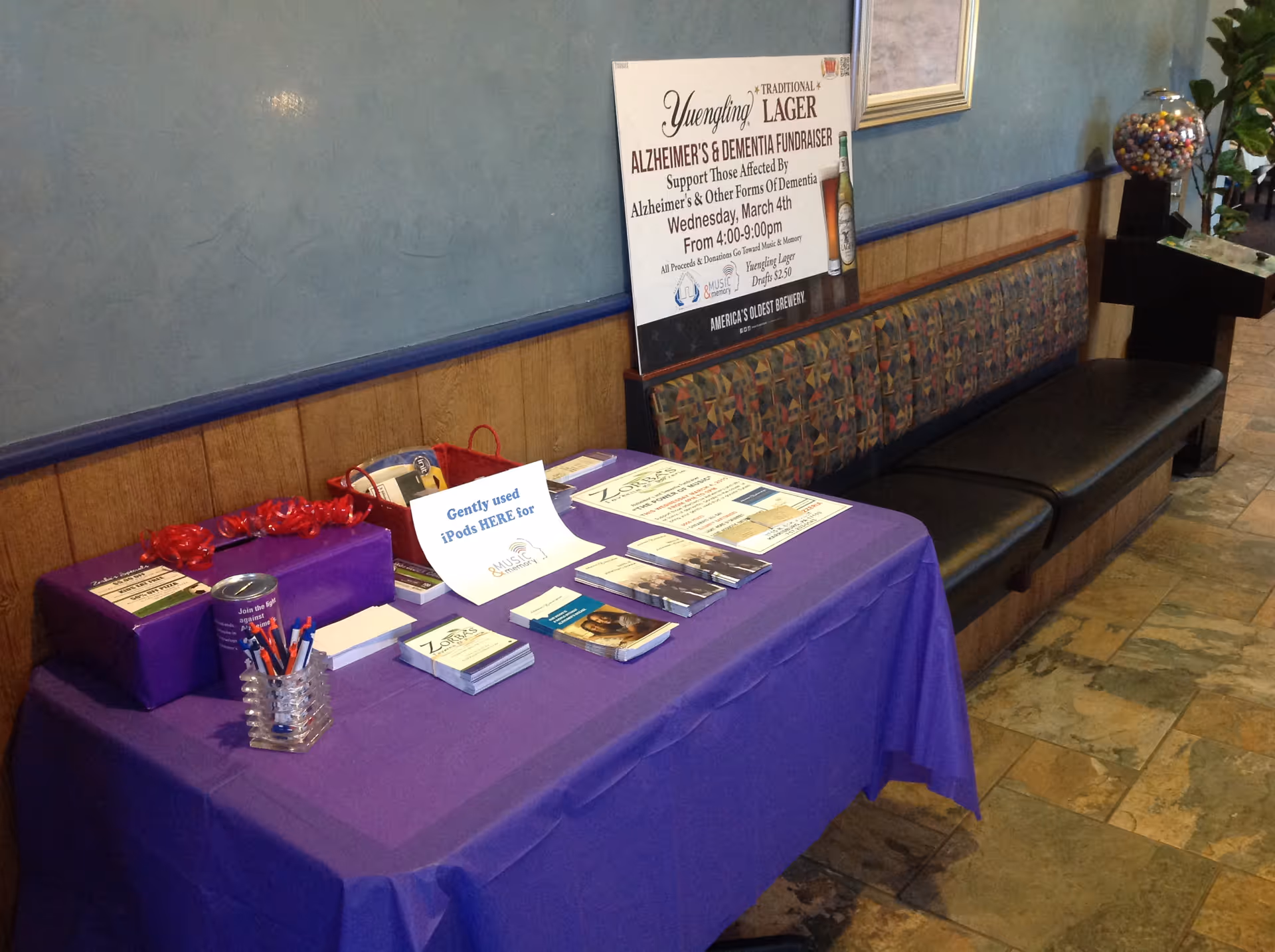 Lobby area with a long purple table of brochures and promotional materials.