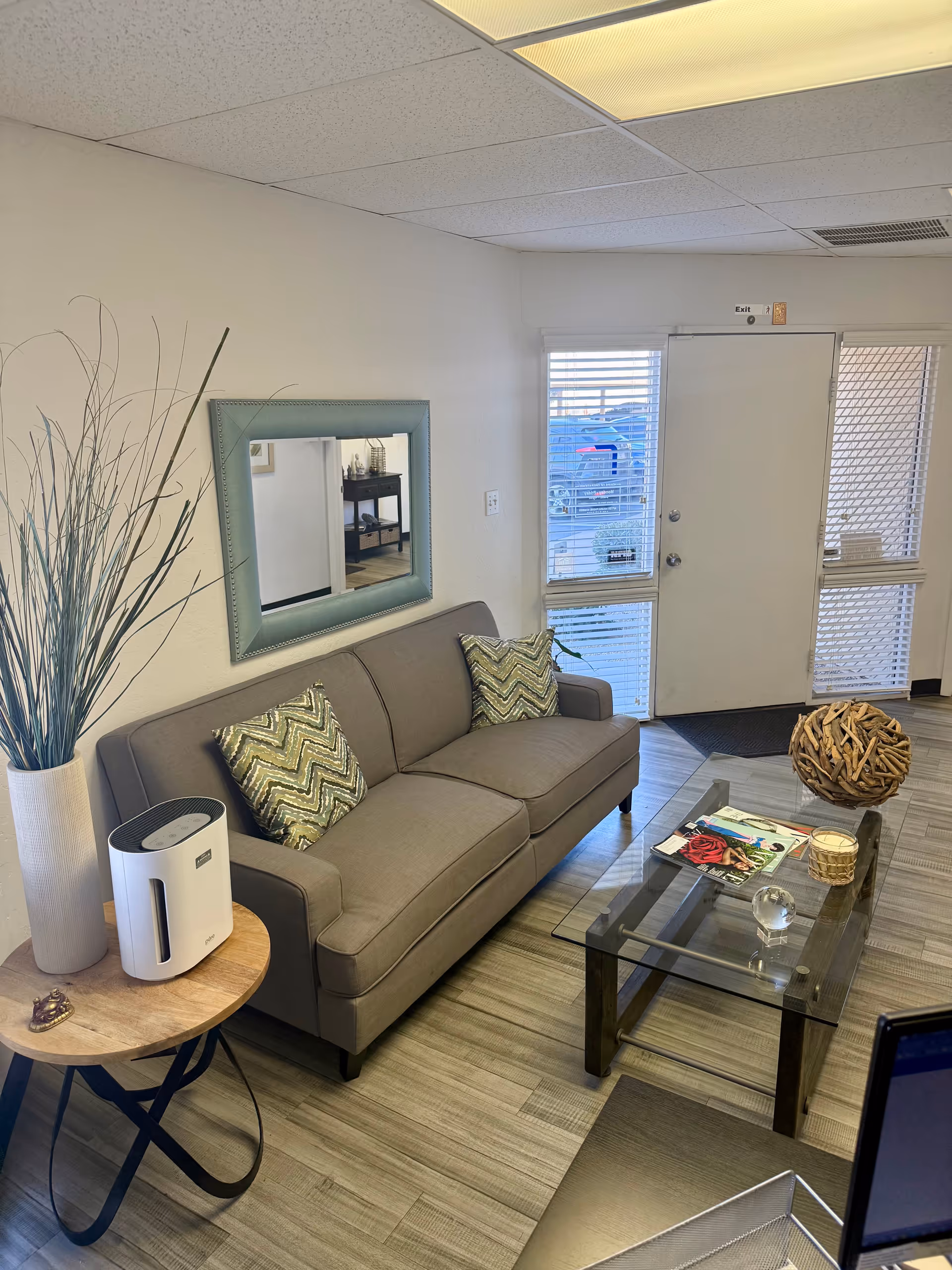 Gray sofa and glass coffee table in a modern lobby lounge.