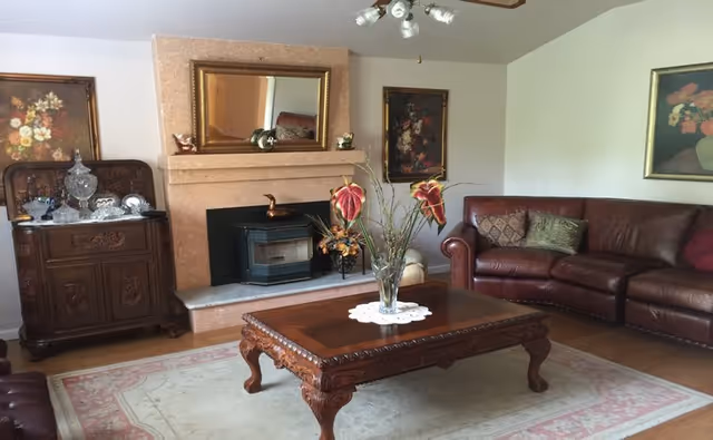 A cozy living room with leather sofa set, a wooden coffee table, and a fireplace.