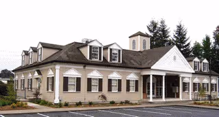 Exterior view of a senior living facility with a front entrance and dormer windows.