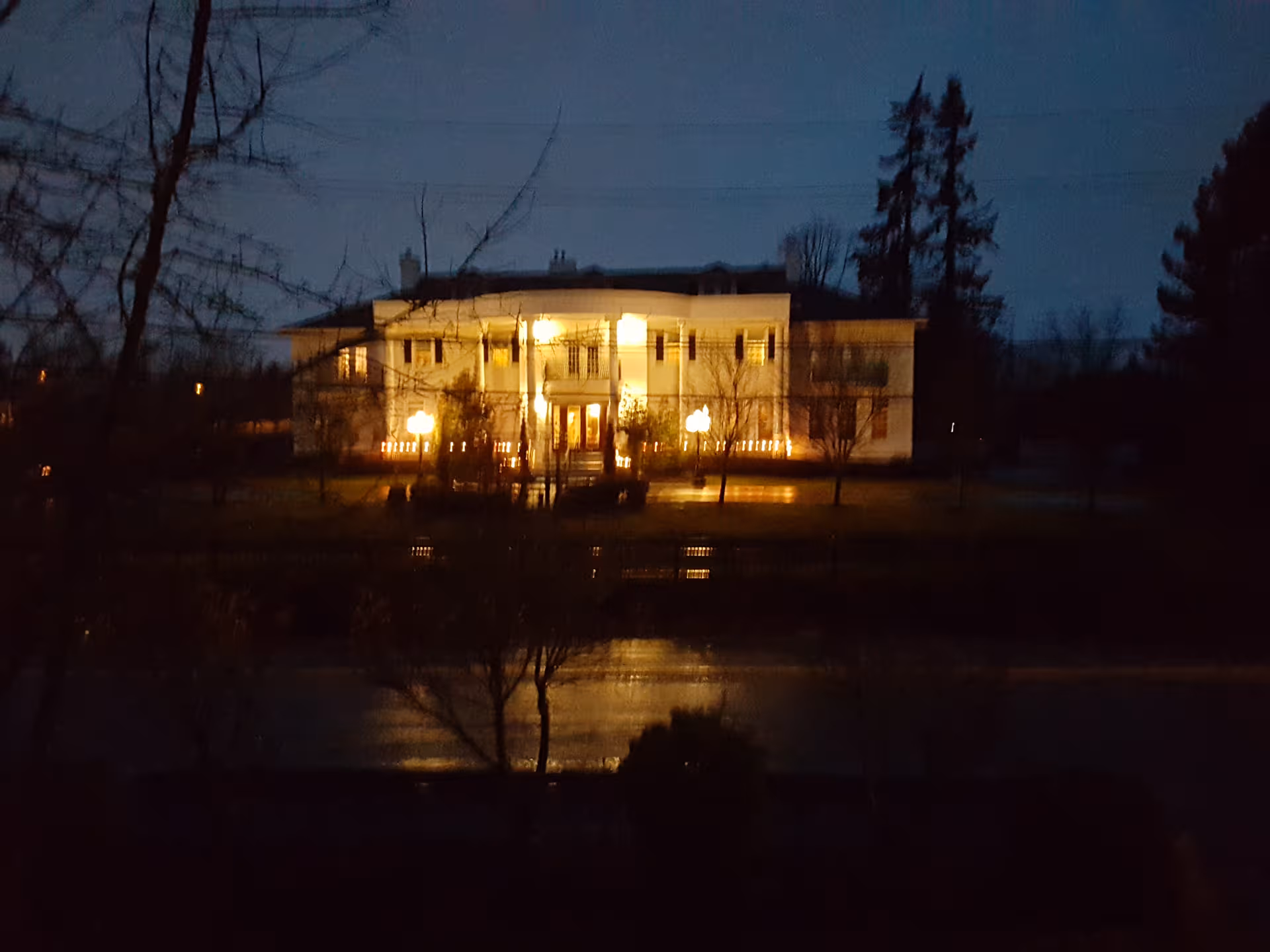 Nighttime exterior of Fairgate Estate, a two-story building with warm lit entryways.