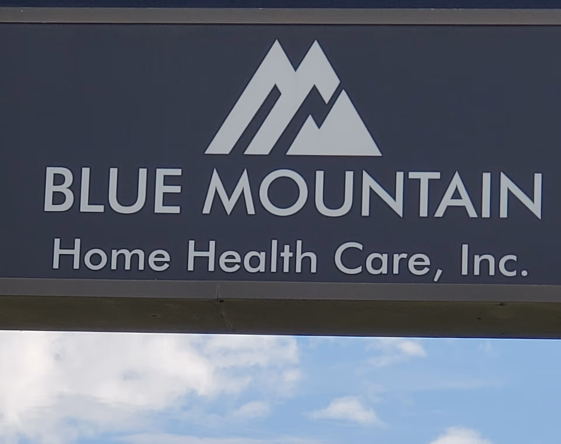 Outdoor sign for Blue Mountain Home Health Care, Inc. with mountain logo.