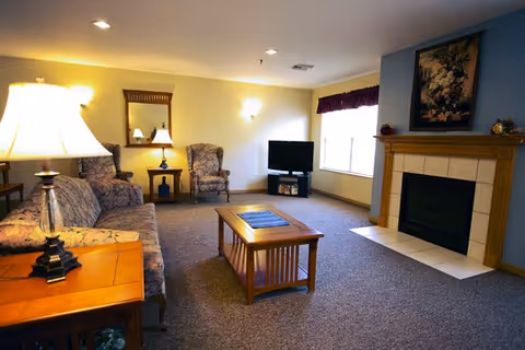 Spacious living room with sofa set, coffee table, fireplace, and TV.