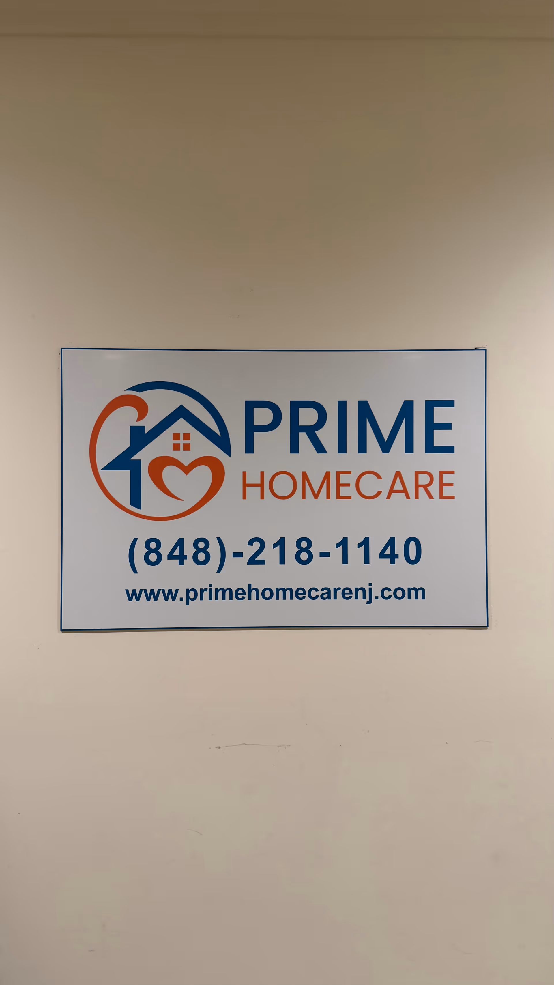Indoor wall sign with Prime Home Care NJ logo, phone number, and website.