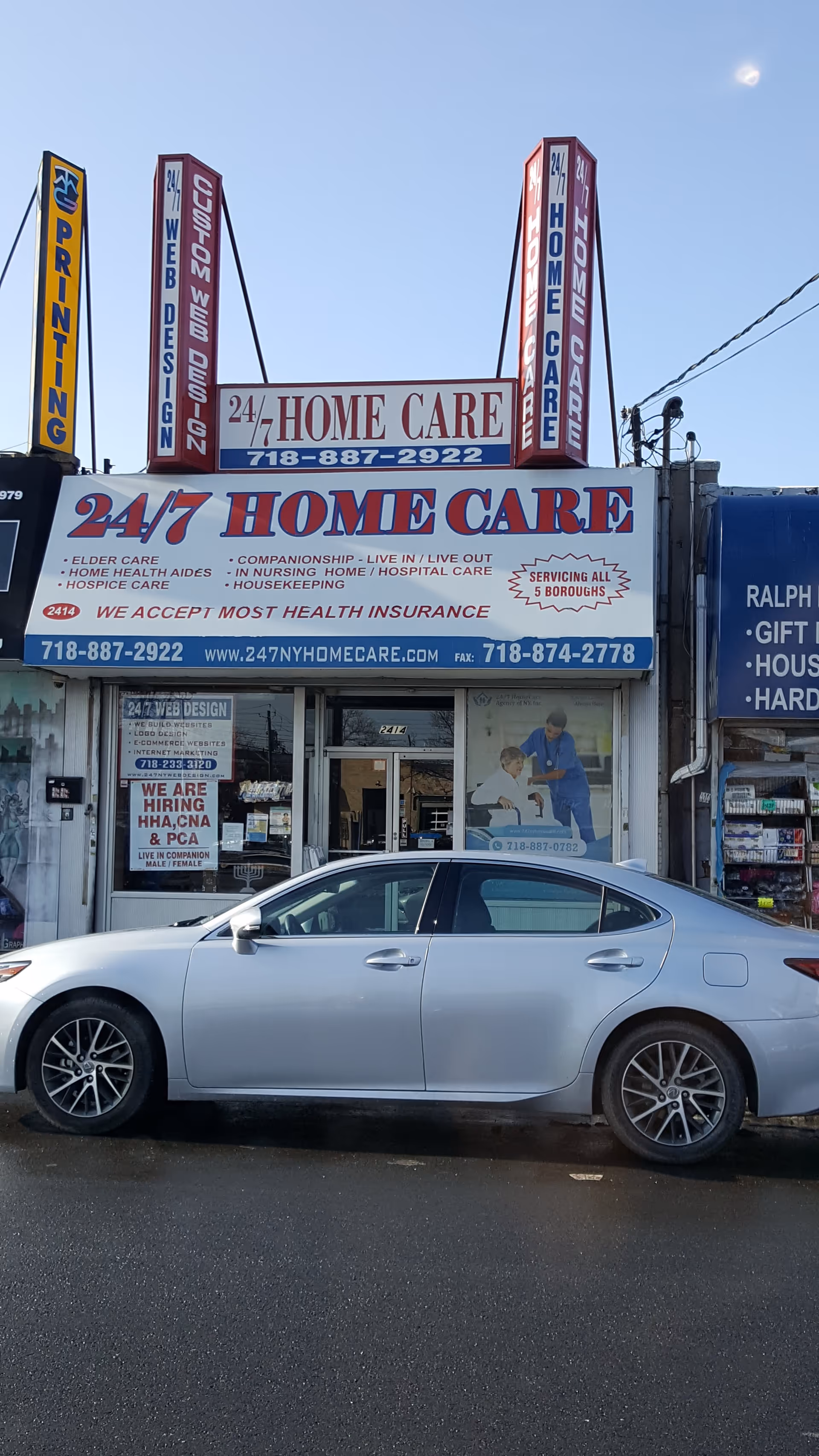 Storefront displaying 24/7 Home Care signs with a silver car parked at front.