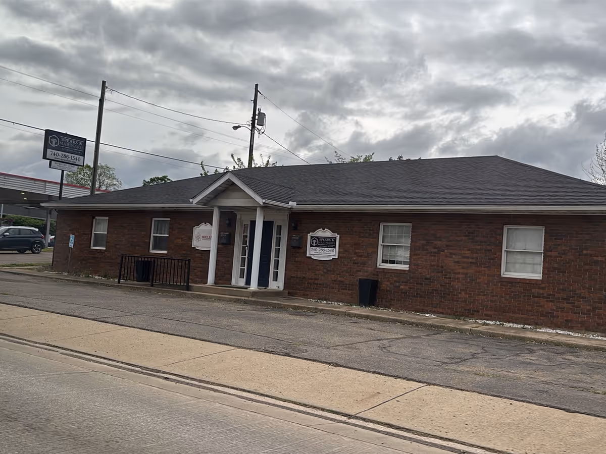 Brick, single-story facility exterior with entrance, signage, and a street-facing façade.