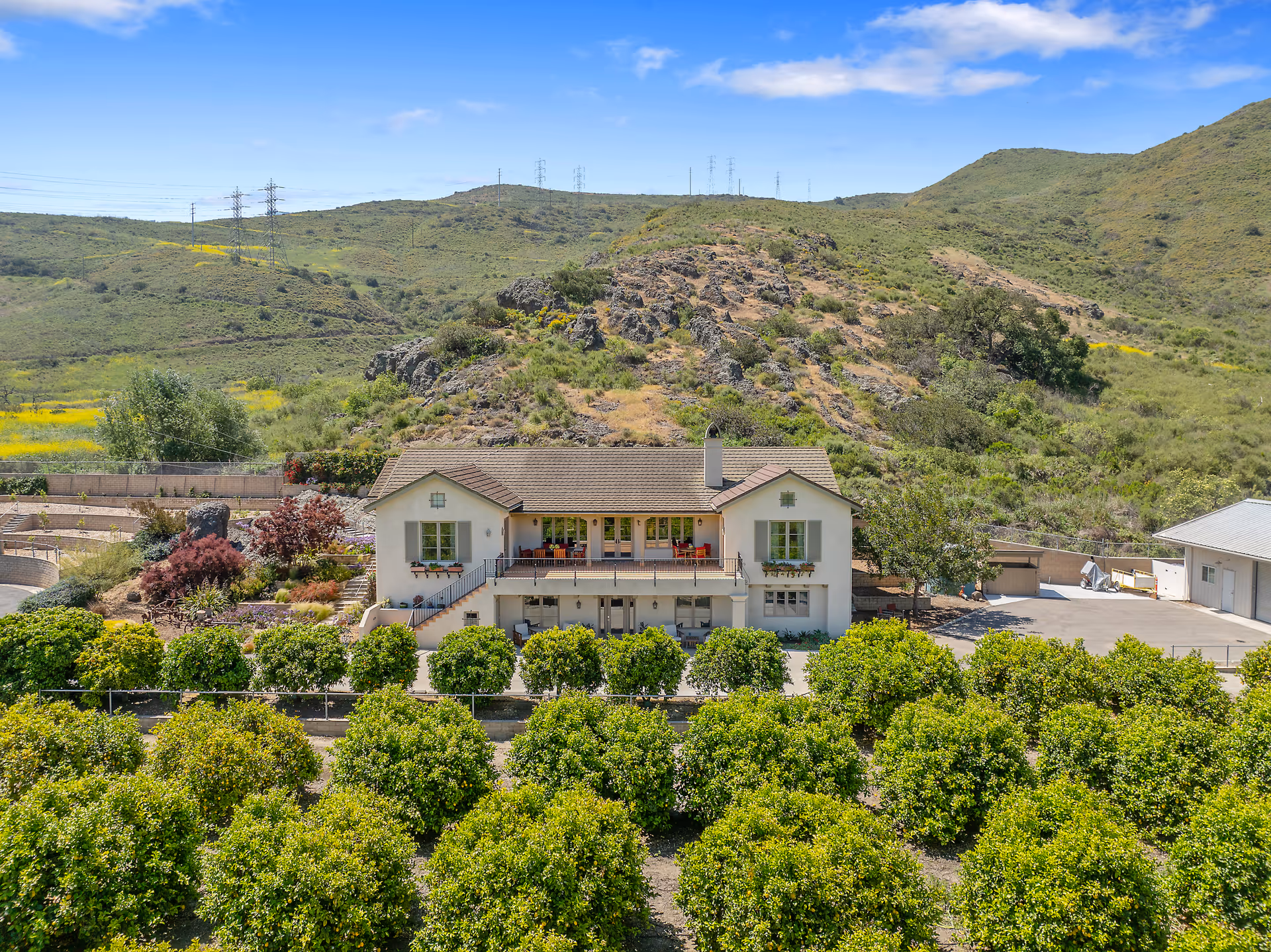 The Orchard senior living facility on a hillside, with orchard rows in the foreground.