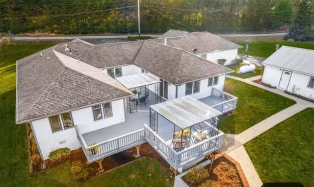 Aerial view of a single-story senior living home with white siding and outdoor decks.